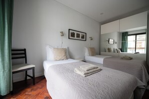 A hotel room with two beds, a chair, a mirror, and a framed picture on the wall. - A-MO Porto by Trip2Portugal (Porto)