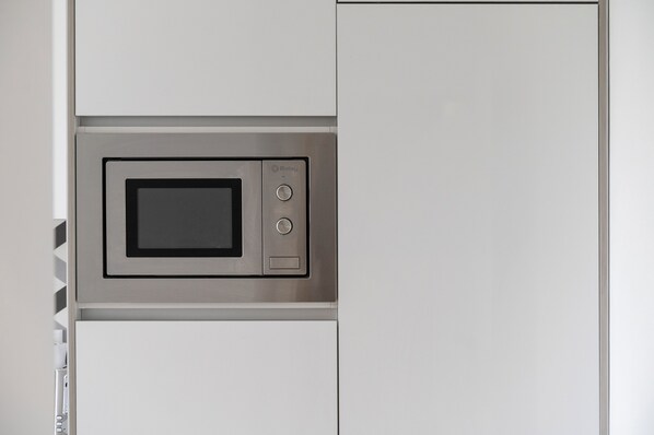 A microwave integrated into a white cabinet, likely in a kitchen setting. - A-MO Porto by Trip2Portugal (Porto)