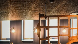 A modern interior with a geometric wooden partition, leather seating, and pendant lighting. - Pegard Andenne Centre (Andenne)