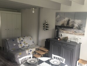 A compact living space with a sofa, dining table, and cabinets.