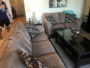 A living room with two sofas, a coffee table, and a lamp.