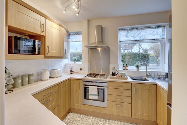 Enjoy cooking in this well-equipped kitchen with stainless steel appliances and a large window.