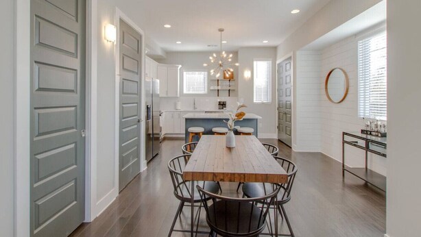 A spacious kitchen with white cabinets, a central island, and a dining area with a wooden table and chairs. - Modern Luxe Escape | Rooftop Views | Near Downtown (Nashville)