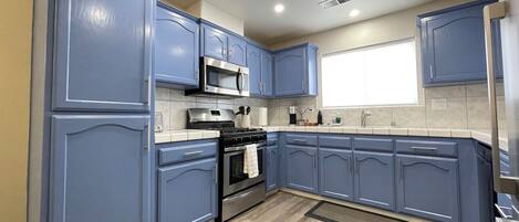 Fridge, coffee/tea maker, cookware/dishes/utensils, dining tables