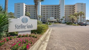 Sterling Sands -niminen hotelli, jossa on useita kerroksia, kauniisti maisemoitu sisäänkäyntialue ja pysäköintialue.