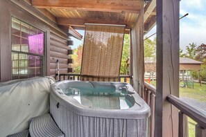 A hot tub on a wooden deck with a view of a house and trees. - Bear Claw Cove #2 Pet Friendly-Hot tub-Kayak  (Pipestem)