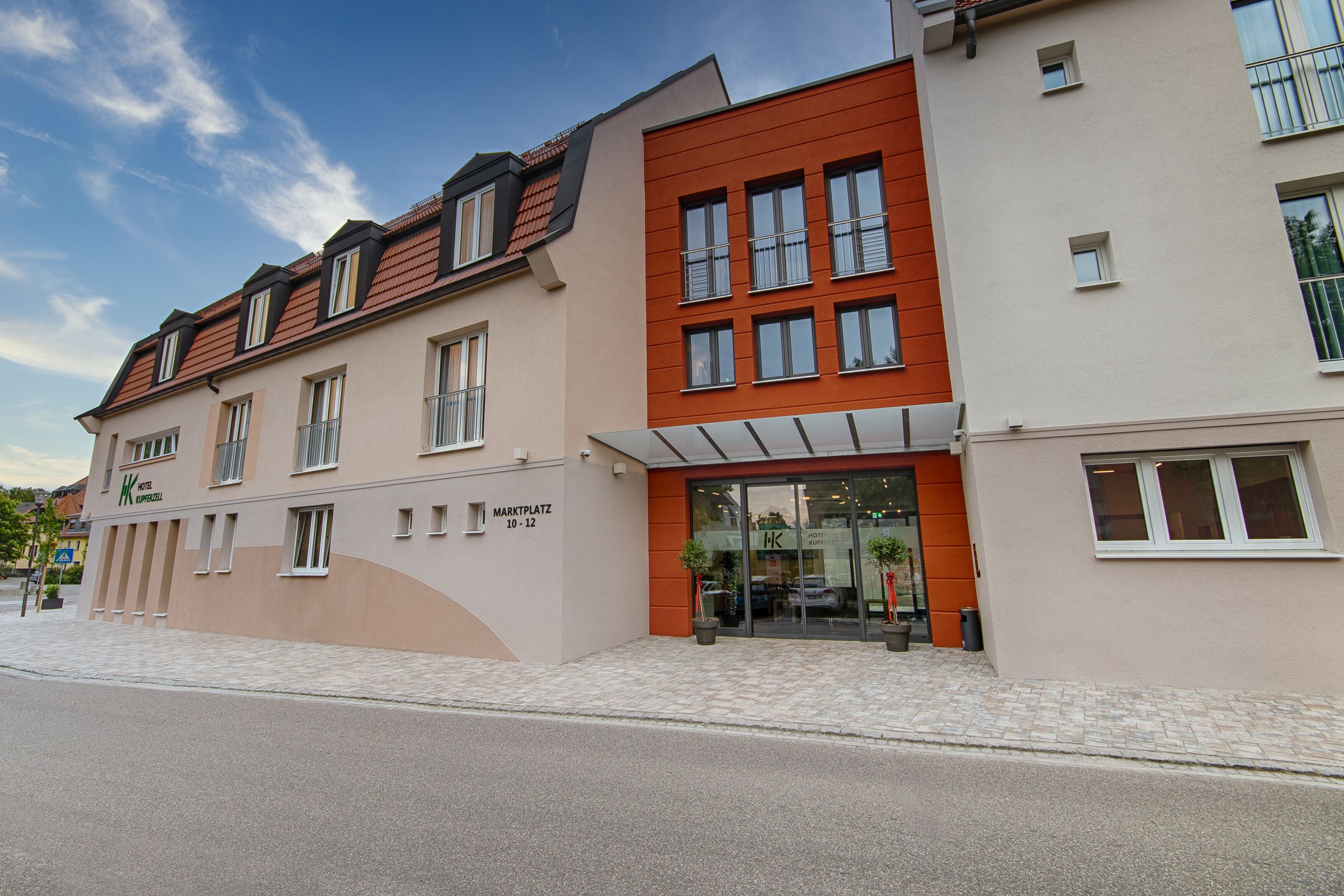 Et hotel med en moderne facade, store vinduer og en markant indgang.