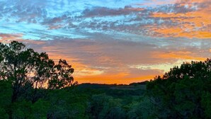 Atardecer sobre un paisaje boscoso con cielo despejado.