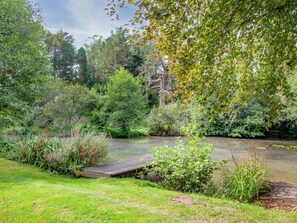 A natural landscape with a wooden bridge over a calm river, surrounded by lush greenery and trees. - 2 bedroom accommodation in Modbury (Modbury)