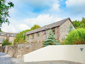 Un bâtiment en pierre avec un toit en pente, une petite fenêtre et un lampadaire.