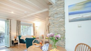 A cozy dining area with a wooden table, chairs, and a vase of flowers. - 2 bedroom accommodation in Modbury (Modbury)