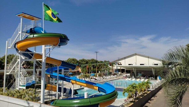 Un parc aquatique doté d’un toboggan aquatique à plusieurs niveaux, d’une piscine et d’un bâtiment à la façade blanche.