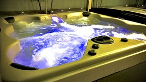 Een jacuzzi met waterstralen en bedieningsknoppen.