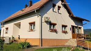 A two-story house with a tiled roof, multiple windows, and a small porch area. - Guesthouse Žafran- Double Room With Terrace (Plitvicka Jezera)