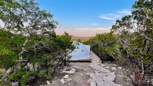 A stone pathway leading to a covered area with a view of the landscape.