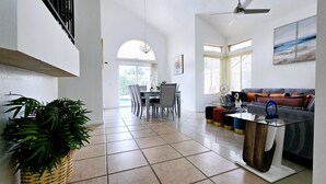 A spacious living area with a dining table, chairs, a sofa, and a coffee table.