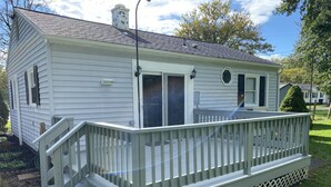 A single-story house with a front porch and a small deck.