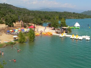 A beach with canoes, kayaks, and a small hut. - Luxury villa with a SWIMMING POOL, air conditioning, near the LAKE and the SEA (Montauroux)