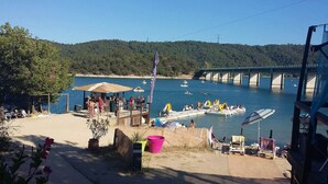 Une vue sur la plage avec une jetée en bois, un pont en arrière-plan et des bateaux sur l’eau.