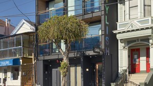A multi-story hotel with a modern facade, large windows, and a tree in front. - The Hotel Castro San Francisco (San Francisco)