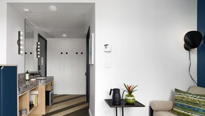 A modern living room with a sofa, a coffee table with a plant, and a wall-mounted lamp. - The Hotel Castro San Francisco (San Francisco)