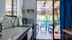 Una cocina moderna con protector de vidrio, un lavamanos integrado y un comedor con mesa y sillas.