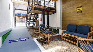 Una terraza de madera con un adhesivo de tiburón azul, un banco de madera y un letrero de advertencia sobre tiburones.