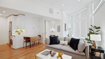 A modern apartment with a kitchen, dining area, and living room.