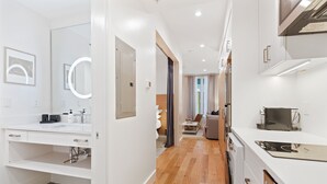 A modern kitchen with white cabinetry, a built-in oven, and a microwave. - The Iris Charleston (Charleston)