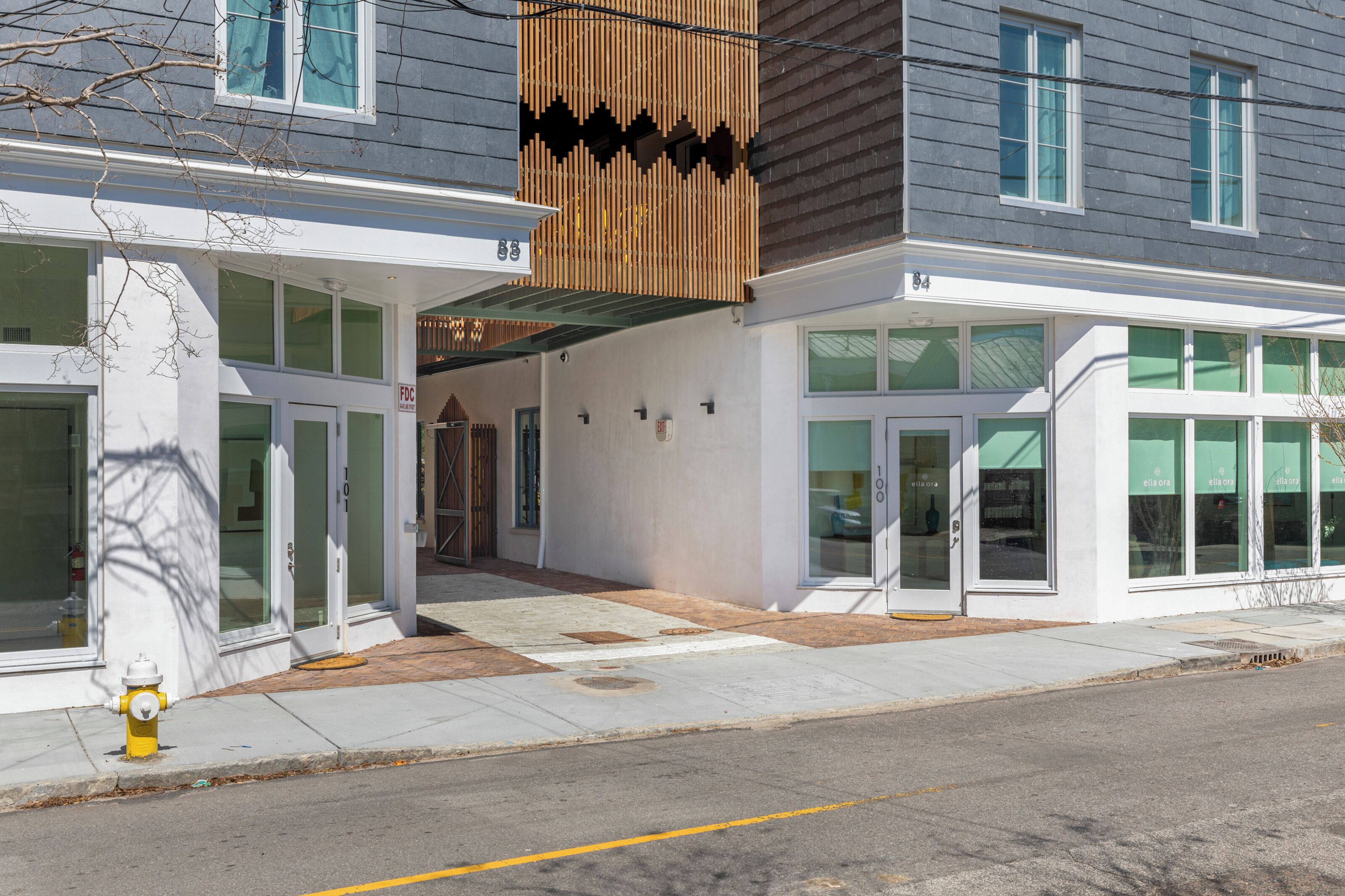 A modern building with large windows, a fire hydrant, and a sidewalk.