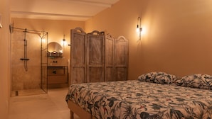 Une chambre à coucher avec un lit, une armoire en bois et un espace douche.
