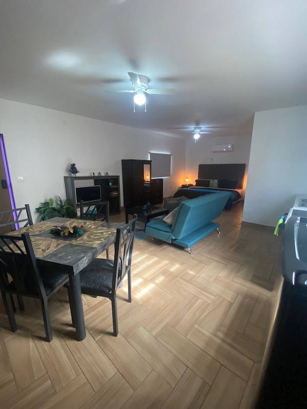 A modern living room with a dining area, a sofa, and a ceiling fan. - loft verde (puerto peñasco)