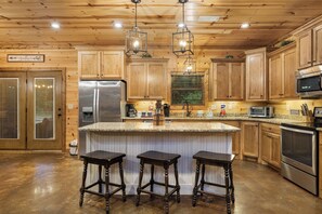 A kitchen with wooden cabinets, a stainless steel refrigerator, a microwave, and a granite countertop.
