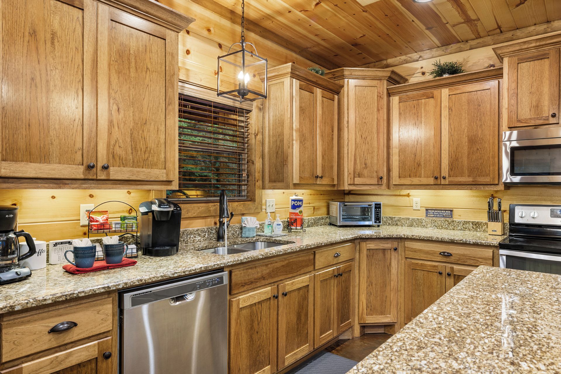 A kitchen with wooden cabinets, a built-in oven, a coffee maker, and a dishwasher.