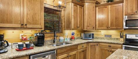 A kitchen with wooden cabinets, a built-in oven, a coffee maker, and a dishwasher.