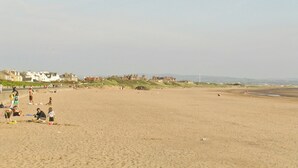 A wide sandy beach with people engaging in various activities. - 1 bedroom accommodation in Girvan (Girvan)