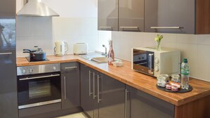 A modern kitchen with stainless steel appliances, a built-in oven, a toaster, and a coffee maker. - 1 bedroom accommodation in Girvan (Girvan)