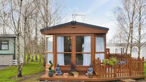 Une petite cabane en bois avec un porche, deux statues de Bouddha et une pancarte indiquant « Yale Retreat ».