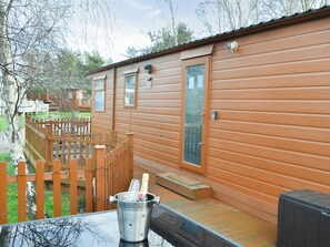 A wooden cabin with a deck and a fenced yard. - 2 bedroom accommodation in Felton, near Morpeth (Felton, near Morpeth)