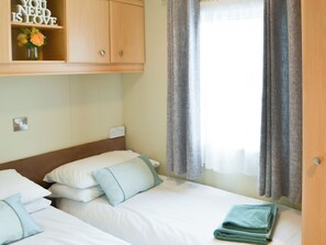 A hotel room with two beds, a small cabinet with a motivational sign, and a window with curtains. - 2 bedroom accommodation in Felton, near Morpeth (Felton, near Morpeth)