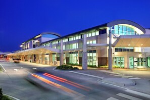 Um edifício moderno com telhado curvo e grandes janelas, provavelmente um hotel ou complexo de escritórios.