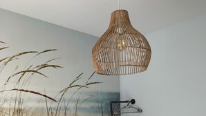 A bedroom with a bed, a white dresser, a hanging light fixture, and a wall mural of tall grasses. - Apartment in guarded residence overlooking swimming pool (Platja d'Aro)