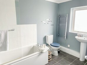 A bathroom with a bathtub, toilet, and sink. - 5 bedroom accommodation in Hayling Island (Hayling Island)