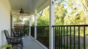 A covered porch with a table and chairs, a ceiling fan, and a view of a wooded area. - Rugby Road Residential -RRR- near UVa and downtown (Charlottesville)