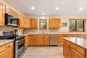 A kitchen with wooden cabinets, a stainless steel oven, a microwave, and a dishwasher.