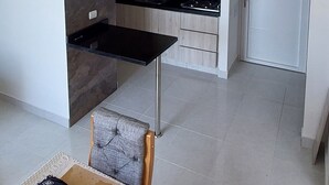 Eine moderne Küche mit schwarzem Arbeitsplatz und einer weißen Tür im Hintergrund.
