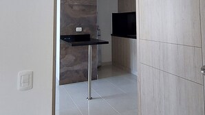 Eine moderne Küche mit Steinrückwand, schwarzem Arbeitsplatz und Holzschränken.