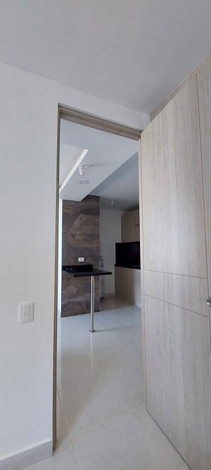 A modern kitchen with a stone backsplash, a black countertop, and a wooden cabinet.