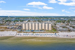 Un hotel di grande altezza con diverse facciate, un'area piscina e posizione fronte spiaggia.
