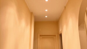 A hallway with a curved ceiling, recessed lighting, and a closed door. - Sea and Relax Portosole private apartment (Sanremo)